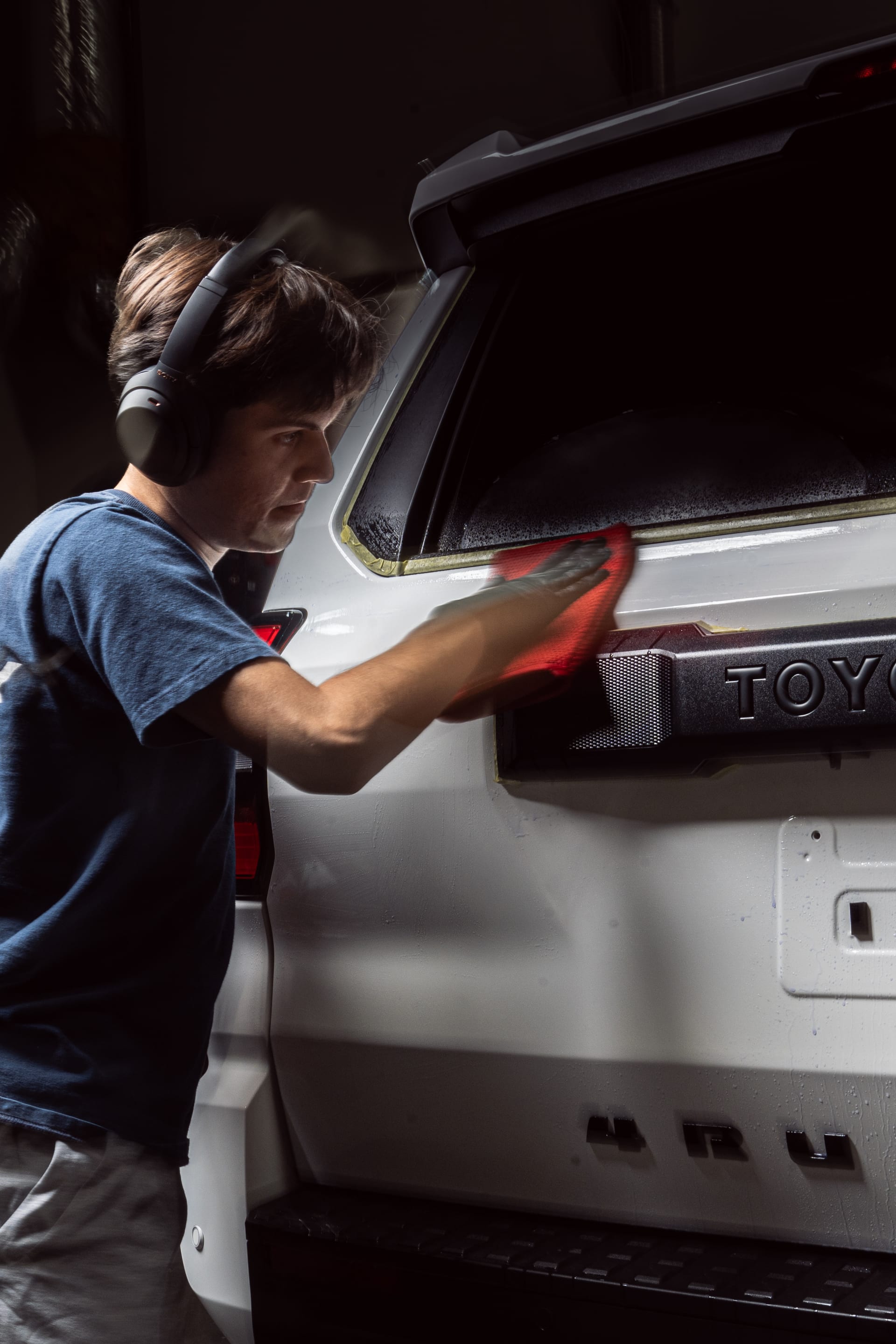 Exterior detail — hand wiping down a Toyota 4Runner