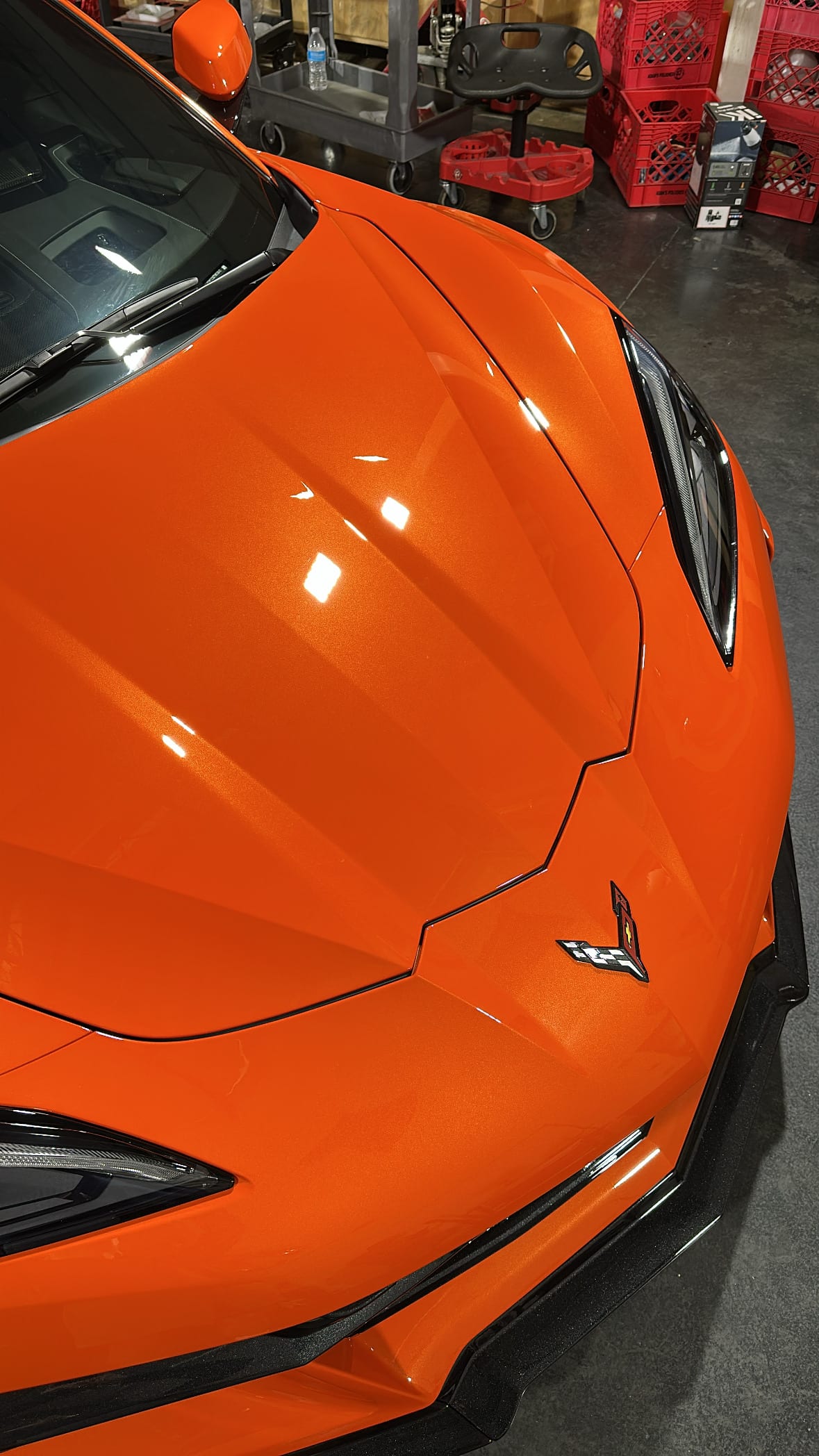 Paint correction on an Orange C8 Corvette showing flawless hood finish